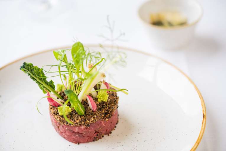 A spiced beef tatare, romanesco, broccoli mooli, radish and parmesan with truffle dressing