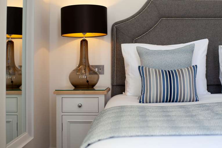 Close up of lamp on bedside cabinet in luxury hotel room