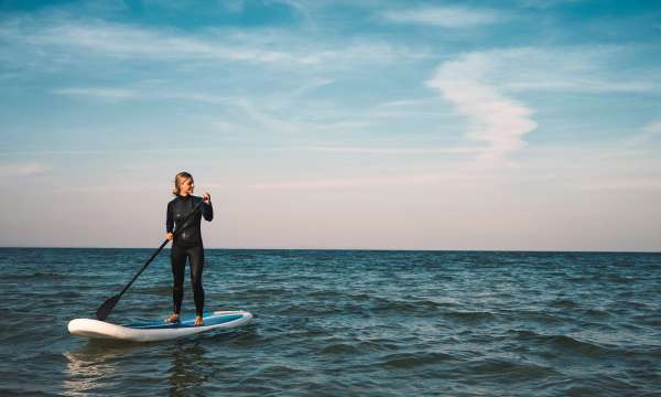 Female Stand up paddleboarding at sea
